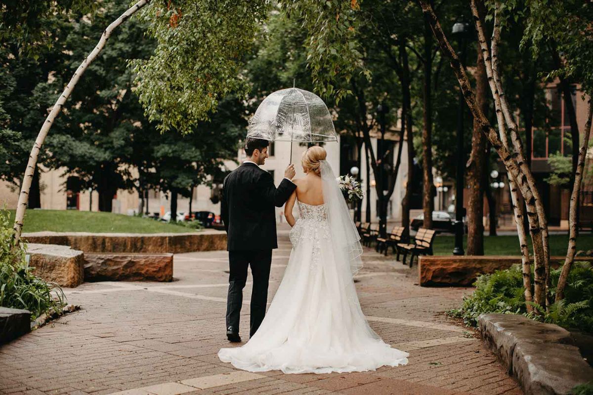 bride and groom walking in park