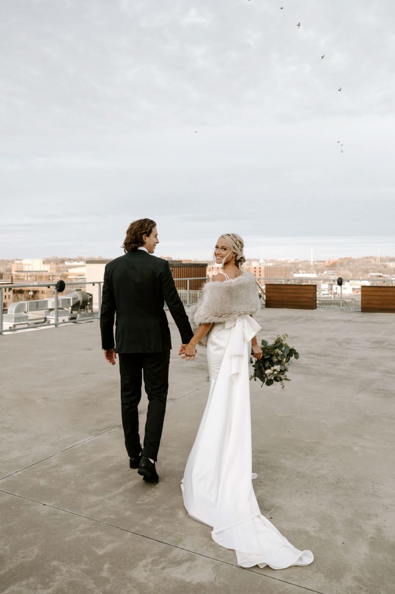 couple holding hands on rooftop