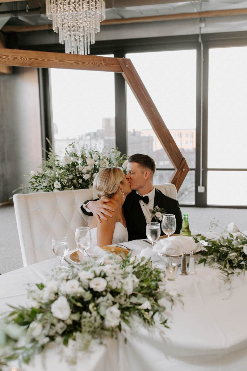 couple kissing at head table