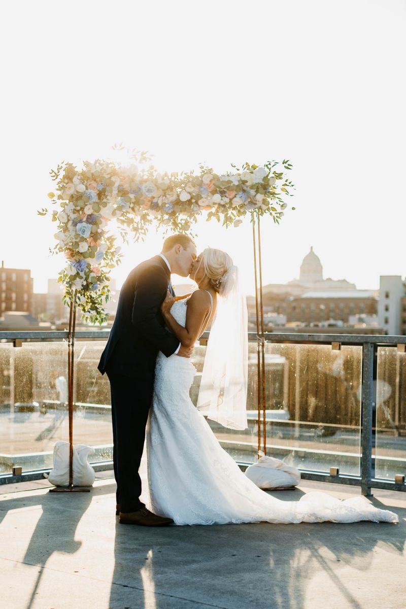 couple kissing under arbor