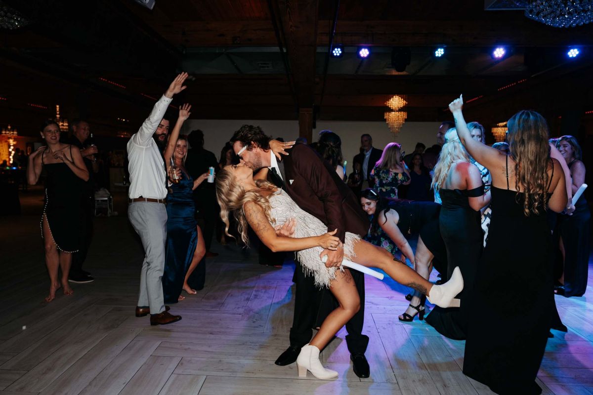 Bride and group posing on dancefloor at A'BULAE