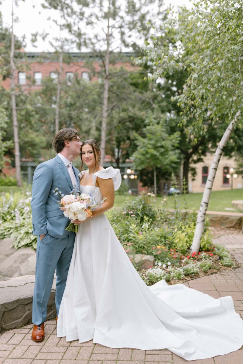 groom kissing bride on the cheek